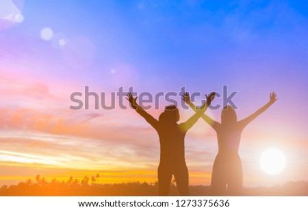 Two happy successful women raising arms toward beautiful scenery. People achieve life target goal. Business women  raises hands as a winning victory. Teamwork concept.