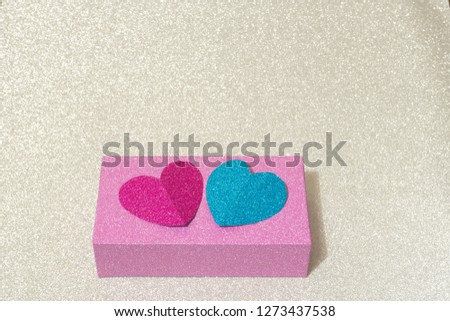 one box decorated with pink and red hearts on silver background. conceptual