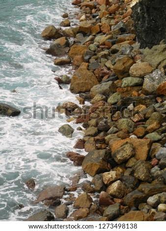 Sea ​​stones on the shore at high tide
					
