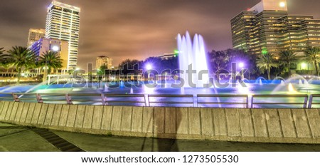 Night skyline of Jacksonville with buildings and square fountain, Florida.