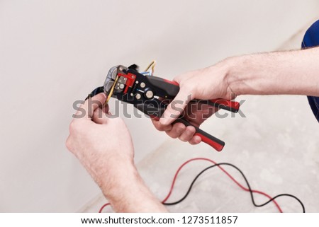 Hands man make connection terminal wire, hold crimping pliers. Design background. Professional materials. Electric work. Male hobby