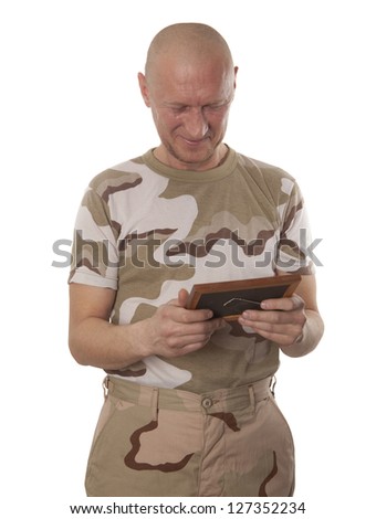 Soldier looks at the photo of the girlfriend isolated over a white background