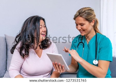 Shot of a young doctor holding a tablet and talking to her patient. Health visitor and a senior woman with tablet. Shot of female nurse and senior woman using digital tablet together 