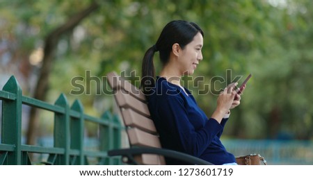 Woman use of mobile phone in the park