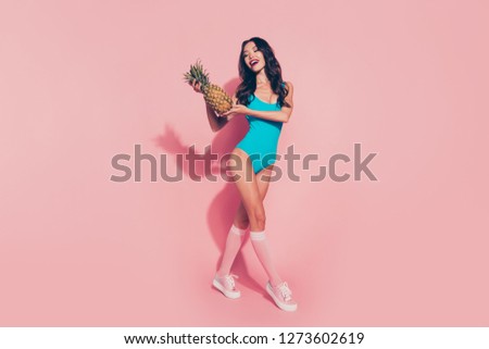 Full length body size portrait of cheerful funny funky careless gorgeous glamorous wavy-haired lady red lips shoes sneakers footwear holding ananas in hands isolated over pink pastel background