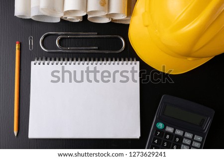 Engineer's desk prepared for work. Accessories prepared for a builder on a black table. Dark background.