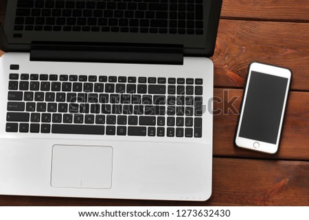 Laptop and phone on wooden background