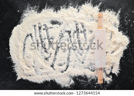 The background of baking. rolling pin and flour on a black background. Top view. Free copy space.