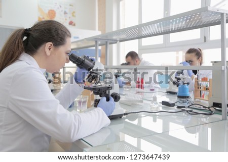 Group of young Laboratory scientists working at lab with test tubes and microscope, test or research in clinical laboratory.Science, chemistry, biology, medicine and people concept. Royalty-Free Stock Photo #1273647439