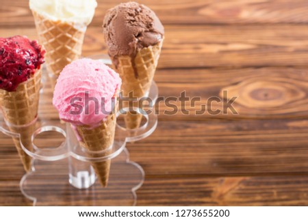 Ice cream waffle cones with berries , chocolate and vanilla