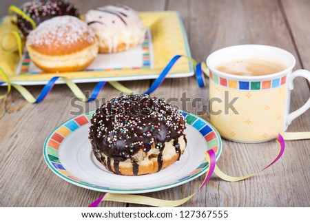 Chocolate and coconut donuts with carnival decoration. German traditional kreppel for carnival