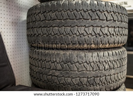 Dirty Tires with clear treads stacked in tire shop with criss cross pattern