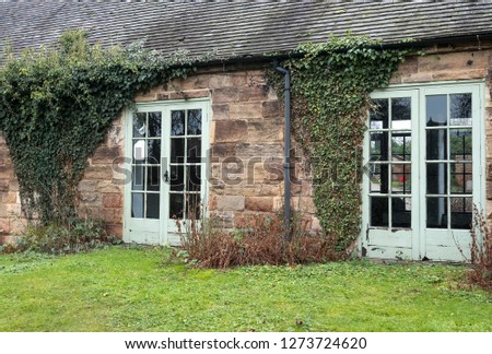 Old cottage building with ivy growing up the wall
