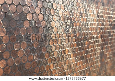 Side view on a wall of copper American pennies, in a currency background