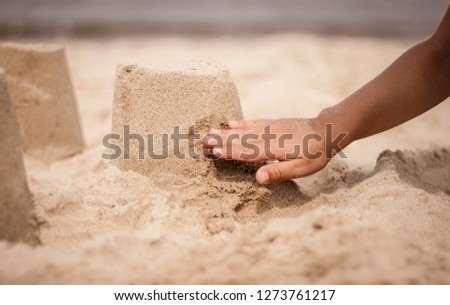 children hand is building a sand castle