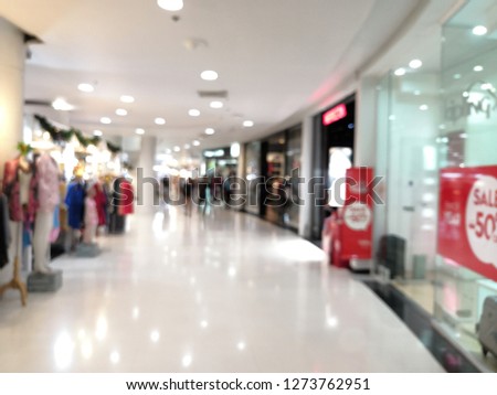 People shopping in department store. Defocused blur background, luxury shopping mall department store with people walking shopped.