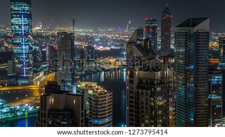 Scenic aerial view of a big modern city at night  with night traffic and illuminated skyscrapers, office buildings. Business bay, Dubai, United Arab Emirates.