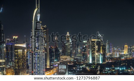 Scenic Dubai downtown skyline  at night with hotels and office building. Top view of Sheikh Zayed road with numerous illuminated towers and skyscrapers. Traffic on the road. Famous landmark