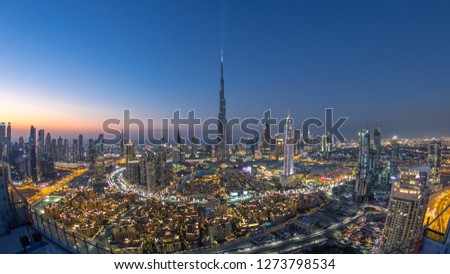 Dubai Downtown day to night transition with building in Dubai and other towers panoramic view from the top before new year celebration in Dubai United Arab Emirates. Lights turning on. Fisheye lens
