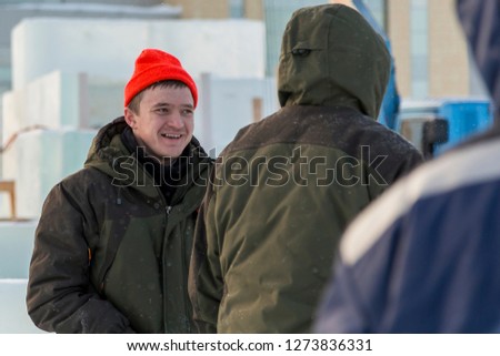 A working assembler in a sports hat in red has a good mood