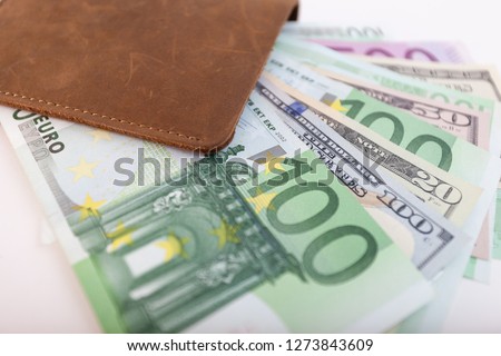 wallet with euro and dollars sticking out of it