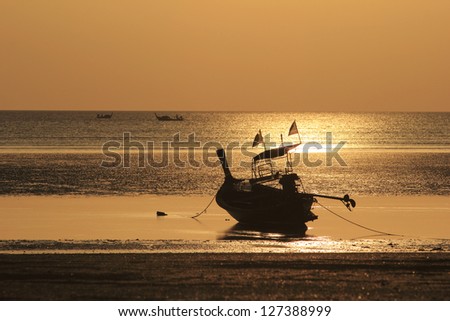 The last rays of the Andaman Sea. A beached long tail boat landing.