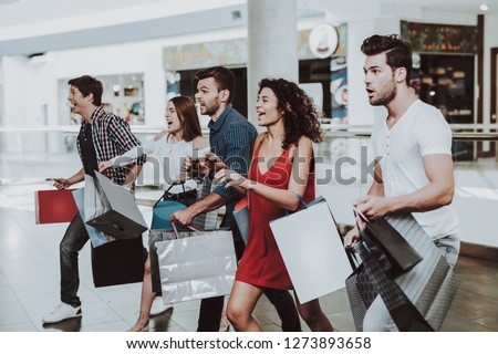 Company of Friends Shopping in Mall with Packages. Shopping Concept. Girl in Red Dress. Woman in White Shirt. Black Friday Concept. Exited Young People. Modern Market. Packs in Hands. Royalty-Free Stock Photo #1273893658