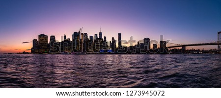 Panorama of a Lower Manhattan at sunset from Brooklyn Height Promenade. Skyscraper silhouettes back light with last rays of a sun