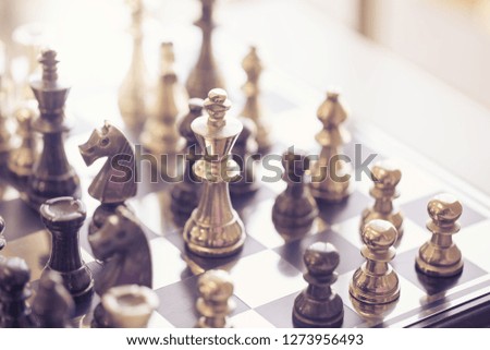 black and silver chessmen on checkerboard, concept for business competition