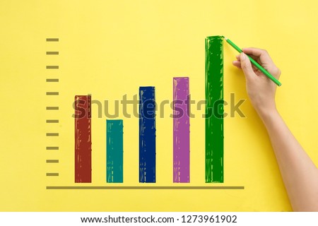 Hand drawing business growth chart on yellow background.