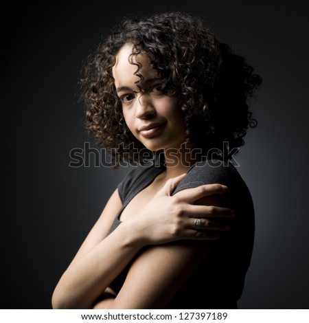 Side view of a teenage african american girl holding her shoulder