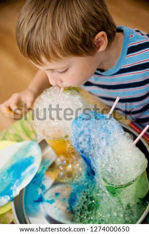 The child blows colored soap bubbles