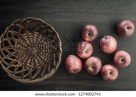 Wooden dark background. Red apples on wooden background, in a basket. Flat lay, top view, space for text.