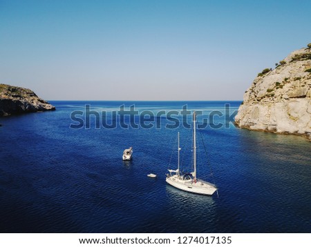 Aerial shot of beautiful blue lagoon at hot summer day with sailing boat. Top view.