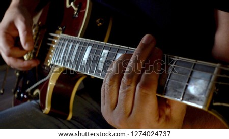 musician playing guitar at studio