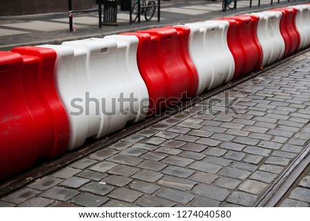 Red and white plastic barriers on the asphalt of the roadway, blocking traffic on the road. Closed passage. Royalty-Free Stock Photo #1274040580