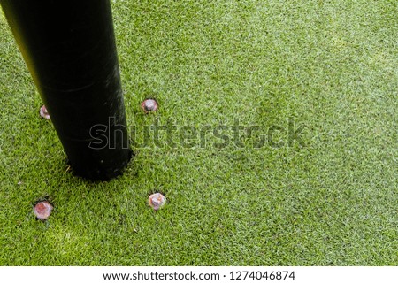 black pole lamp on the artificial green grass background texture - Image