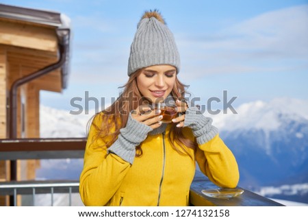             Woman drinking tea in the rustic wooden outdoor cafe mountain summit. Lifestyle adventure concept.                    