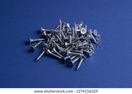 Self-tapping Screws - Perfect for Metal, Plastic and Wood Work.On a bright blue background top view.