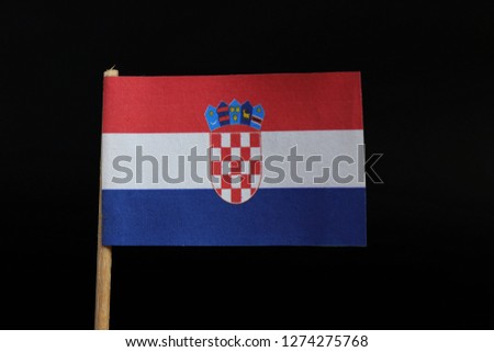 A official and unique flag of Croatia on toothpick on black background. A horizontal tricolour of red, white, and blue with the Coat of Arms of Croatia in the centre.