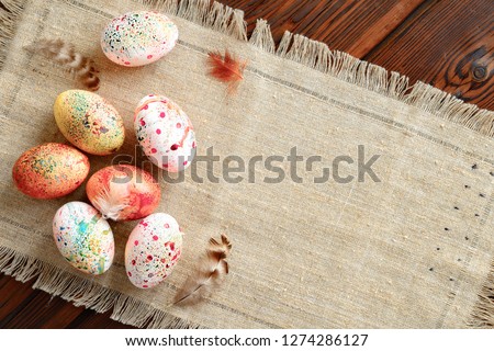 painted colored Easter eggs on canvas on dark wooden background Royalty-Free Stock Photo #1274286127