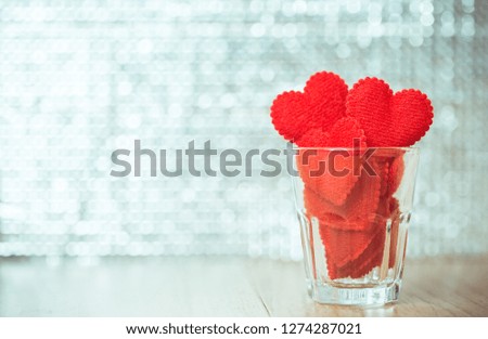red fabric hearts in drinking glass with bokeh background, Valentine's day concept