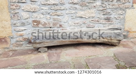 Bench made with a trunk next to a wall