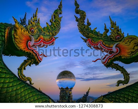 Big Nagas or snakes are architect with glass ball  and sky sunshine in the morning at Wat khaophrakru in the Chonburi ,Thailand