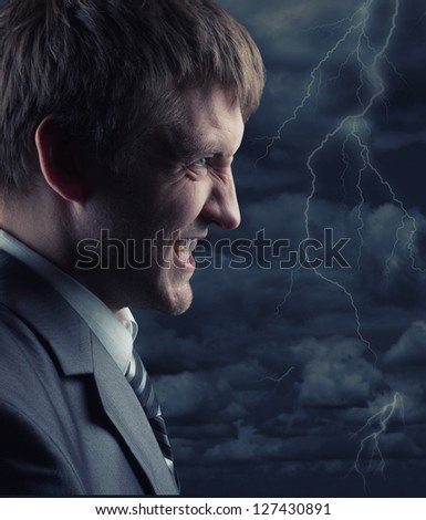 Angry businessman against storm at night