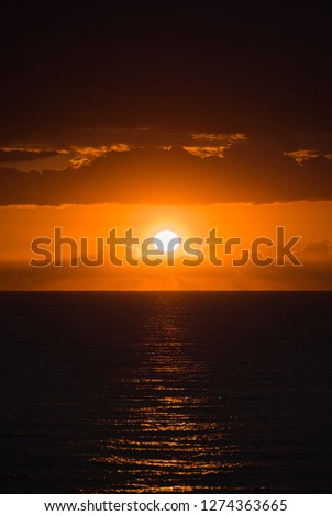 Epic dawn of a new day in golden hour seascape with sun reflections in the ocean. 