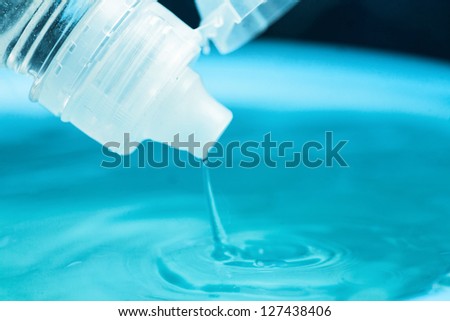 Water splashing out of a water bottle on the blue