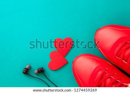 men's shoes, heart and black headphones top view,red sneakers headphones and two red hearts on a blue background