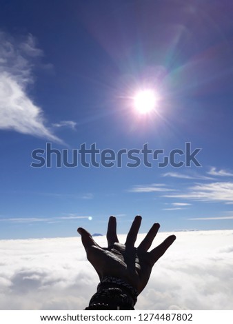 Hand and sun with blue sky