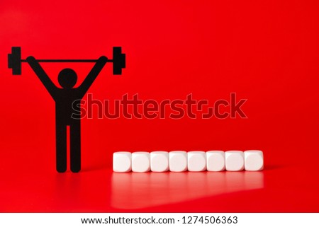 Black weight lifter pictogram with white unlabeled cubes, on red background